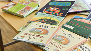 Bir masada çeşitli dillere ait çocuk kitapları duruyor.