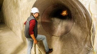 Kanalarbeiter steigt in den Tunnel