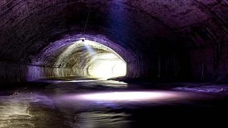 Vaulted sewer bathed in purple light