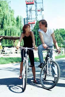 Ein Paar auf Fahrrdern vor dem Wiener Riesenrad