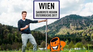 Junger Mann inmitten von Naturgebiet hält Schild mit Aufschrift "Wien Sauberste Region Österreichs 2017"