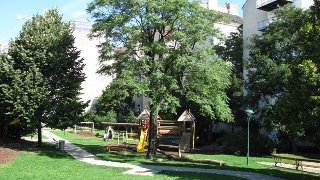 Spielplatzgeräte in einem Park unter Bäumen