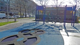 Kinderspielplatz mit blauen Bodenelementen und einer blauen Schaukel