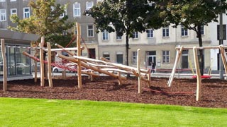 Kinderspielplatz mit Schaukel und schattigen Bäumen