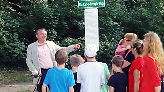 Mann spricht zu einer Gruppe von Kindern