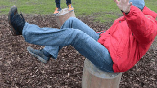 Ein Mann balanciert im Sitzen auf einem sich bewegenden Holzteil