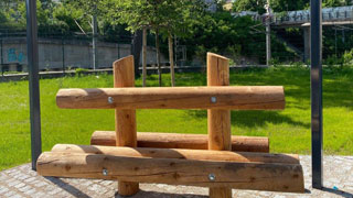 Sitzbank aus Holz unter einer Pergola