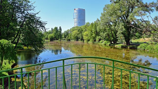 Teich in einem Park, im Vordergrund eine Brücke