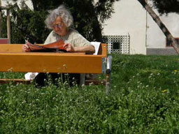 eine Frau sitzt lesend auf einer Bank im Klieberpark