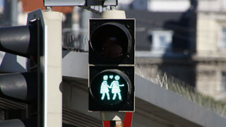 Grne FugngerInnen-Ampel mit zwei handhaltenden Frauen und Herz als Symbol