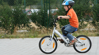 Kind trgt beim Radfahren einen Radhelm