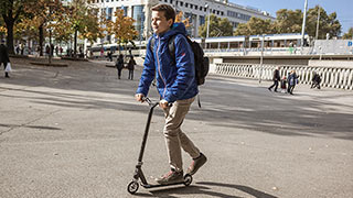 Junge fährt mit einem Micro-Scooter am Karlsplatz