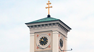 Auenansicht einer Kirche mit einem Turm mit Uhr