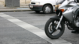 Motorradfahrer und Autofahrer an Straenkreuzung - Detailansicht