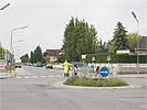 Kreuzungsbereich Adolf-Loos-Gasse - Oswald-Redlich-Strae: Kreisverkehr mit Verkehrsinsel, Bushaltestellen, Zebrastreifen und einem Schlerlotsen
