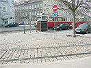 Endstation der Straenbahnlinie D: Breiter Bereich ohne Zebrastreifen mit Straenbahnschienen, Fugngerinseln und Straen mit parkenden Autos