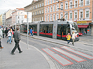 Kreuzungsbereich Quellenstrae - Gellertplatz: Kreuzung mit Straenbahnschienen und rot unterlegtem Zebrastreifen bis zu den Straenbahnschienen