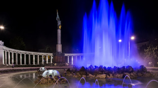 Beleuchtete Wasserfontne des Hochstrahlbrunnens bei Nacht